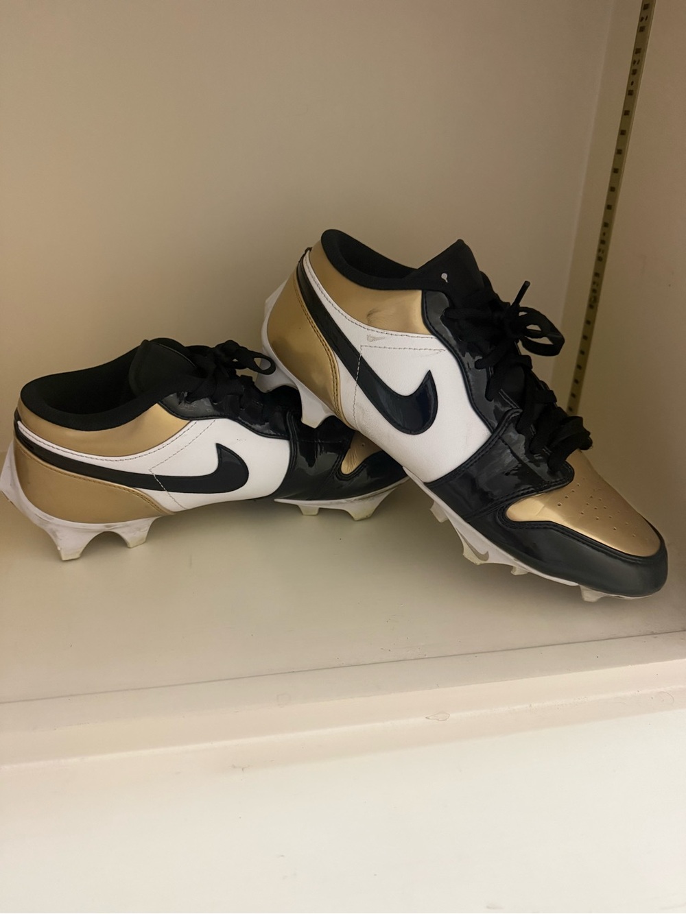Nike Jordan 1 Low TD Football Cleats in Metallic Gold/Black/White colorway.